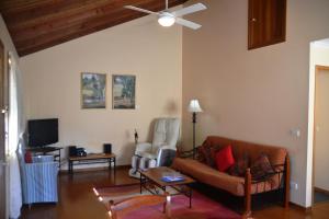 un soggiorno con divano e ventilatore a soffitto di Avoca Cottages VICTORIA ad Avoca