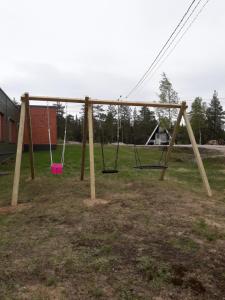 a swing set in a park with a pink bucket at Karemajat Cottage Resort in Ylitornio