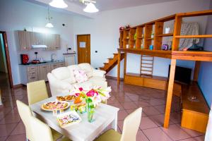 B&B L'Aurora CAPUA في كابوا: غرفة معيشة مع طاولة وكراسي ومطبخ