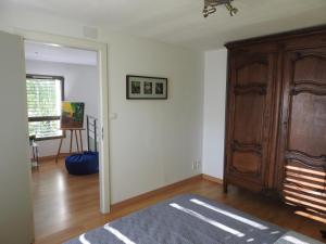 a living room with a wooden cabinet and a door at Le Cube in Nayemont-les-Fosses