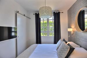 a bedroom with a bed and a window at Les Terrasses du parc Cordier in Trouville-sur-Mer