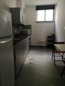 una cocina con electrodomésticos de acero inoxidable y una ventana en Séqua Apartamento, en Tavira