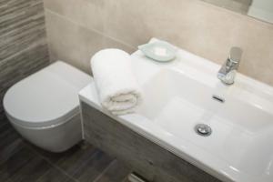 ein Badezimmer mit einem weißen Waschbecken und einem WC in der Unterkunft Nissos Poros in Poros
