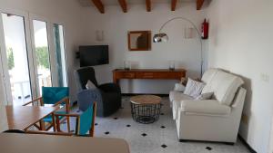 Una sala de estar con un sofá y sillas y una mesa. en Villa Na y Veni, en Cala'n Bosch