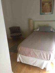 ein Schlafzimmer mit einem großen Bett und einem Stuhl in der Unterkunft JARDINES DE MURILLO, calle Rastro in Sevilla
