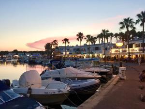 un grupo de barcos atracados en un puerto deportivo al atardecer en Villa Na y Veni, en Cala'n Bosch