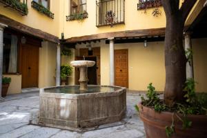 a fountain in the courtyard of a building at Alh Patio Apartamentos in Granada