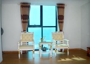 two chairs and a table in front of a window at Phuong Hoang Hotel 2 in Sầm Sơn