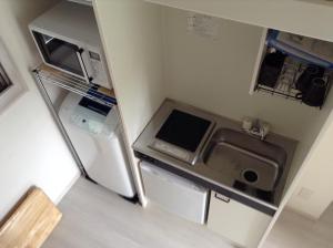 a small kitchen with a sink and a refrigerator at Shitamachi Base in Tokyo