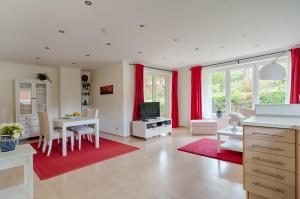 a living room with a white table and red curtains at Ferienhaus - Wittenhögen in Buchholz in der Nordheide