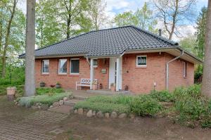 a small red brick house in the woods at Ferienhaus - Wittenhögen in Buchholz in der Nordheide