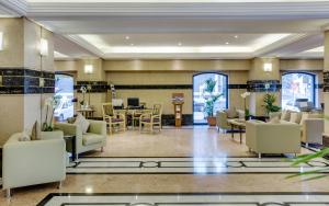vestíbulo con sofás, zona de comedor y vestíbulo en Novel Hotel City Center, en Abu Dabi