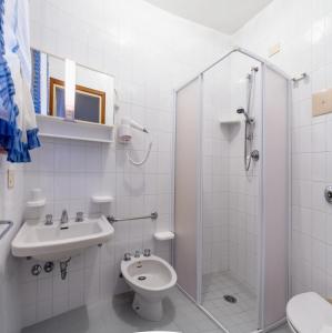 a bathroom with a shower and a toilet and a sink at Appartamenti Bianchi in Bibione