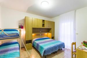 a bedroom with two bunk beds and a cabinet at Appartamenti Bianchi in Bibione