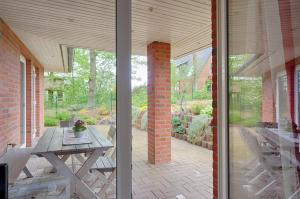 a patio with a picnic table and a brick wall at Ferienhaus - Wittenhögen in Buchholz in der Nordheide