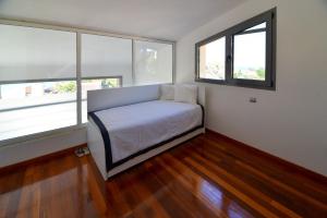 a small bedroom with a bed and two windows at Modern Seaside Villa K2 in Kriopigi