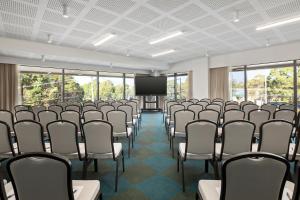une salle de conférence avec un écran et des chaises dans l'établissement Quest Burwood East, à Burwood