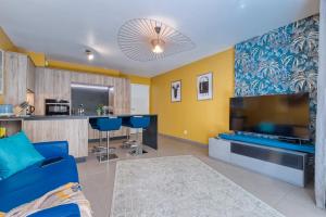 a living room with a blue couch and a large tv at Residence Blue Harmony in Nice