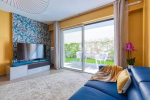 a living room with a blue couch and a sliding glass door at Residence Blue Harmony in Nice