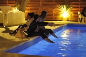 un gruppo di persone seduti accanto alla piscina di Hotel Loretta a Rimini