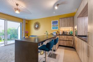 a kitchen with a large island with blue bar stools at Residence Blue Harmony in Nice