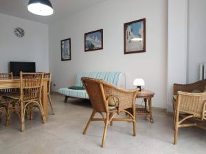 Una sala de estar con sillas, una mesa y un sofá. en Porta Alfonsina, en Otranto