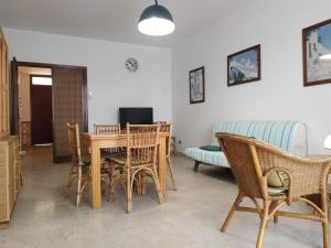 Una sala de estar con una mesa y sillas y un sofá. en Porta Alfonsina, en Otranto