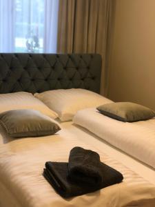 a bed with two pillows and a towel on it at Apartament Beauty in Ełk