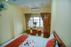 a bedroom with a bed and a window with flowers on it at Cat Ba Bay Vision Hotel in Cat Ba