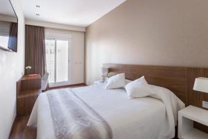 a bedroom with a large white bed and a window at Center City Flats in Valencia