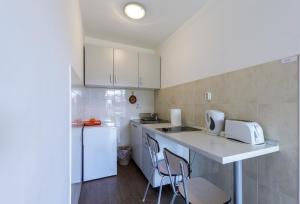 a small kitchen with a counter and a white refrigerator at Guest House Anica in Dubrovnik