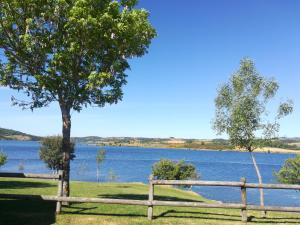 a wooden fence next to a body of water at Casa do Azibo in Santa Combinha