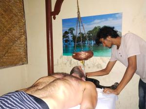 a woman is giving a man a massage at Havelock Farms Resort in Havelock Island