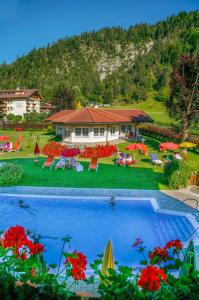 a resort with a swimming pool and a house at Berghof-Chalet in Erpfendorf