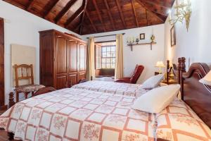 ein Schlafzimmer mit großem Bett und Holzdecke in der Unterkunft El Sitio La Rosa in Mazo
