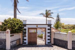 ein Tor zu einer Villa mit dem Meer im Hintergrund in der Unterkunft El Sitio La Rosa in Mazo