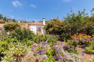 einen Garten mit Blumen vor einem Haus in der Unterkunft El Sitio La Rosa in Mazo