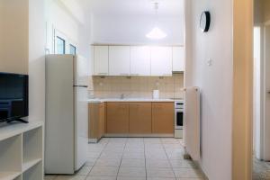 a kitchen with white cabinets and a refrigerator at Pnyka Apartment 2 in Athens +8 photos
