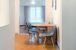 a dining room table with blue chairs in a room at Pnyka Apartment 2 in Athens