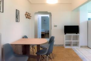 a dining room with a table and chairs and a television at Pnyka Apartment 2 in Athens