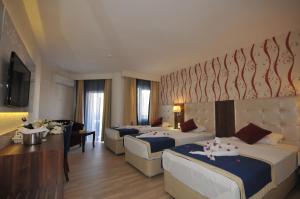 A bed or beds in a room at Kleopatra Micador Otel