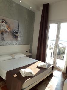 B&B L'Isola في بورتو سيساريو: غرفة نوم بسرير ونافذة كبيرة