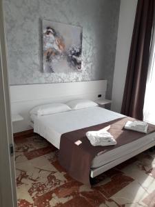 1 dormitorio con 1 cama y una pintura en la pared en B&B L'Isola, en Porto Cesareo