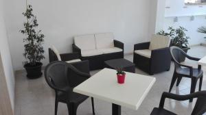 Kali Nitta Salento في سانت إيزيدورو: غرفة بها كراسي وطاولة وأريكة