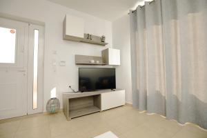 a living room with a flat screen tv and a window at Villa Martini in Kissamos