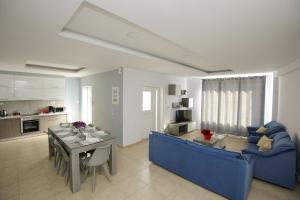 a living room with a blue couch and a table at Villa Martini in Kissamos