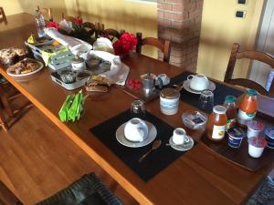 - une table en bois avec des assiettes et de la vaisselle dans l'établissement Villa Bonelli Bed & Fest, à Savillan