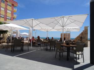 a group of tables and chairs with umbrellas at Rascasa 2/5 in La Mata