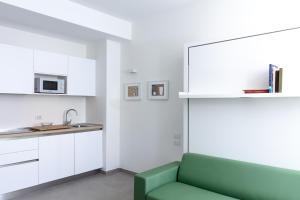 salon z zieloną kanapą w kuchni w obiekcie Cirene Apartments Milano w Mediolanie