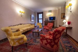 a living room with couches and chairs and a tv at Relais Ducale in Gubbio